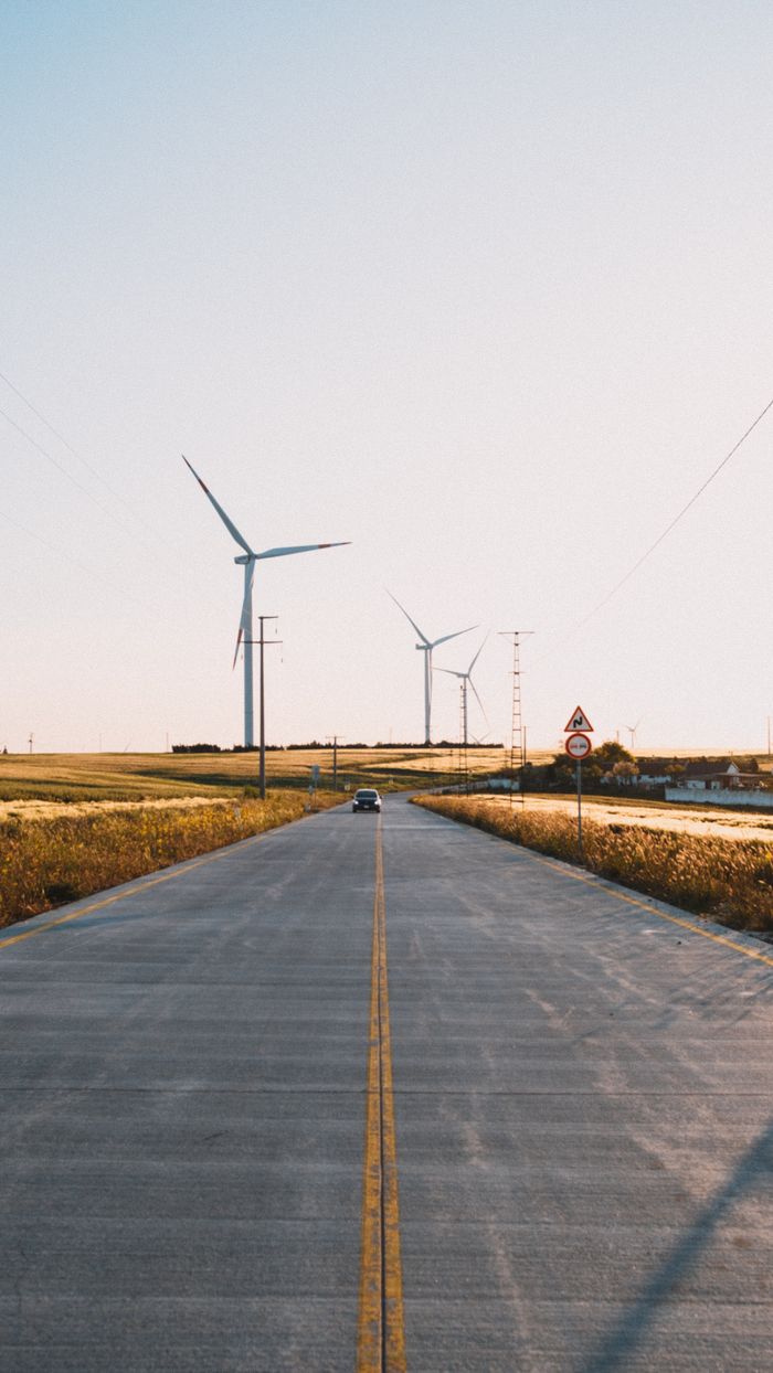 why-choose-us Scenic countryside road with wind turbines in Silivri, highlighting renewable energy and rural landscapes.