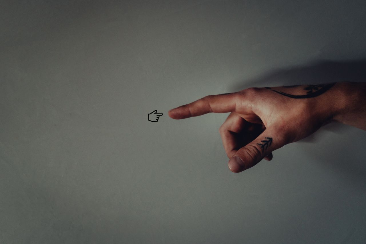 contact-img Tattooed hand pointing with a minimalistic arrow tattoo, symbolizing guidance and direction.