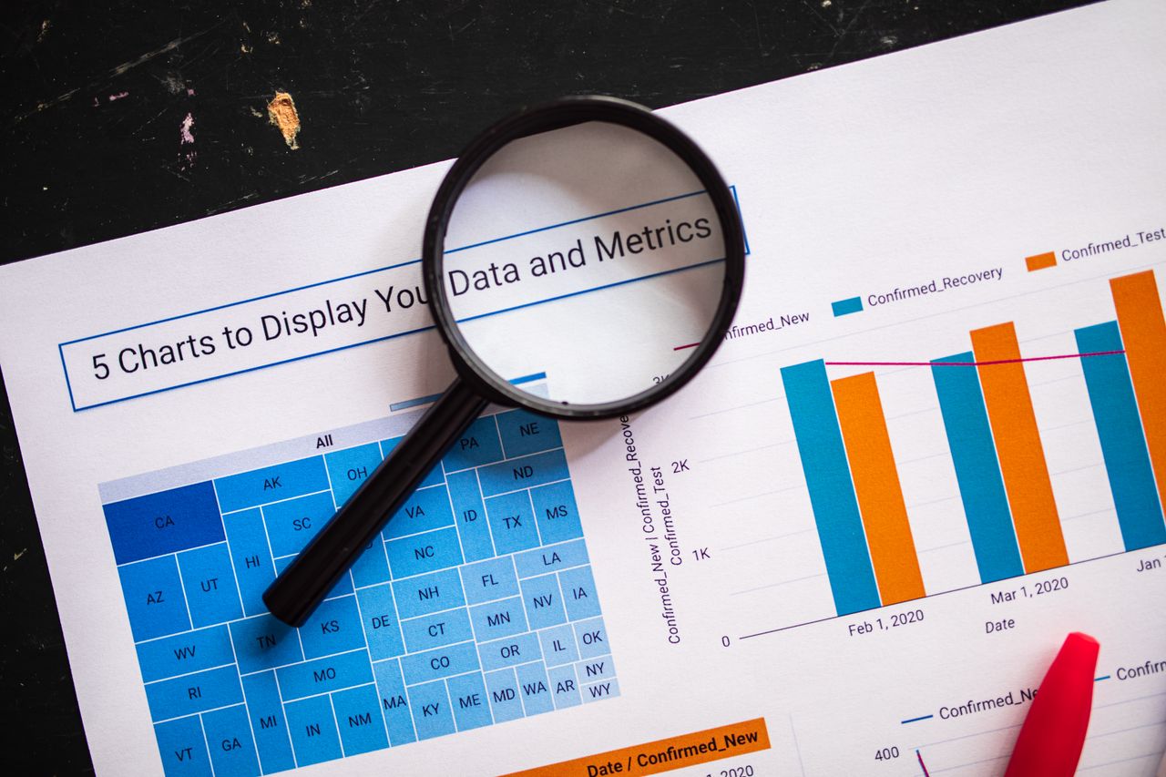 services-03 Close-up of business charts with magnifying glass highlighting data insights.