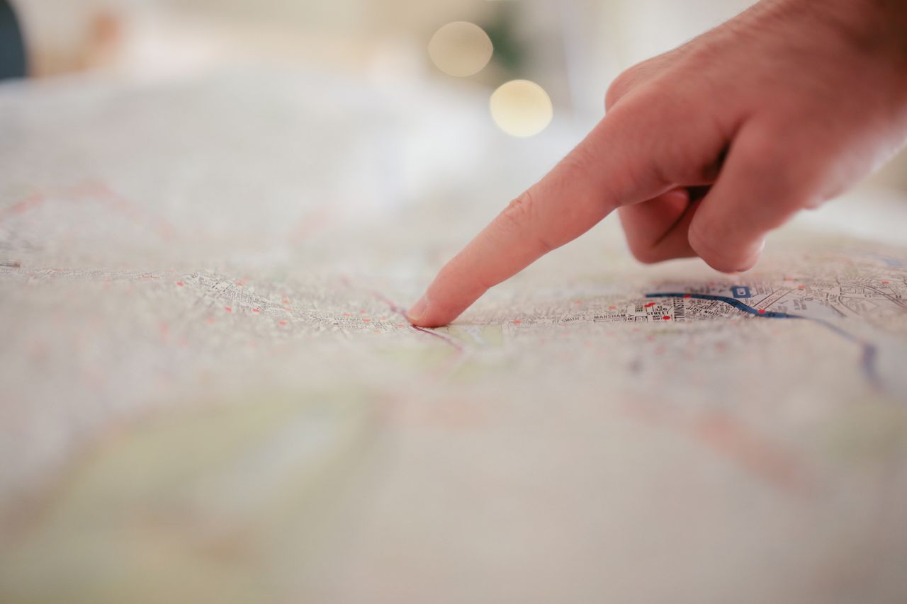 ours-journey A hand pointing at a city map, highlighting direction and navigation planning.